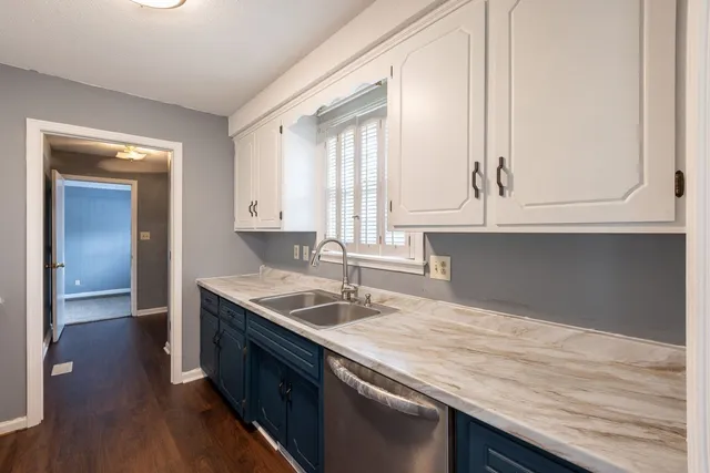 a kitchen with granite countertop a sink and dishwasher with wooden floor