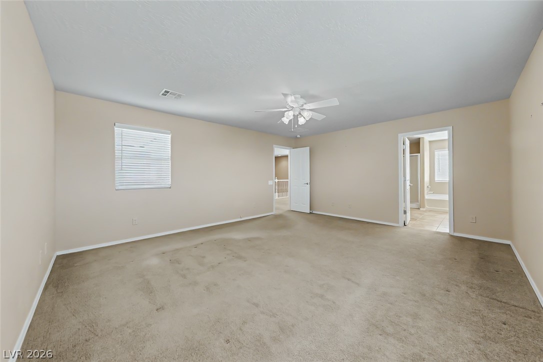 2356 Rue Bienville Way Henderson, NV 89044 - Photo 10 of 20 This spacious bedroom offers ample natural light and direct access to a private bathroom.
