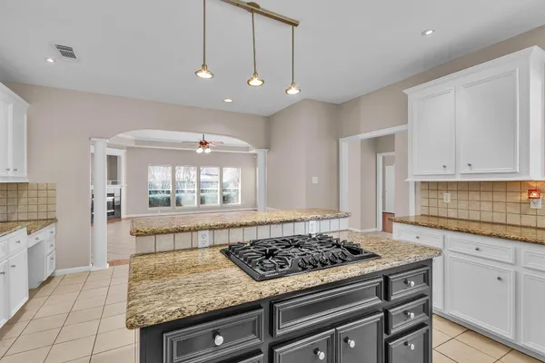 a kitchen with a stove and white cabinets