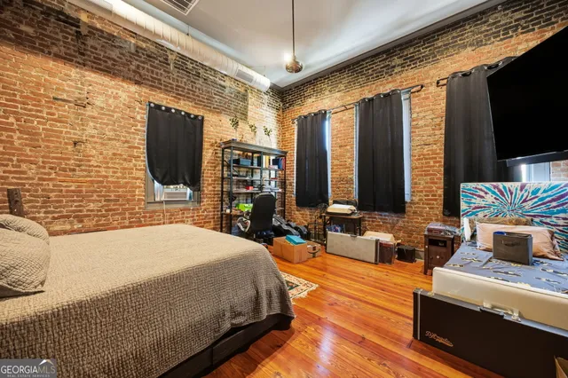 a bedroom with furniture a flat screen tv and a fireplace