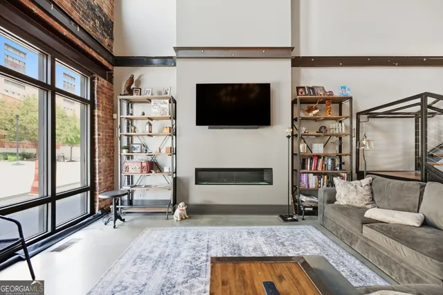 a living room with furniture a flat screen tv and a fireplace