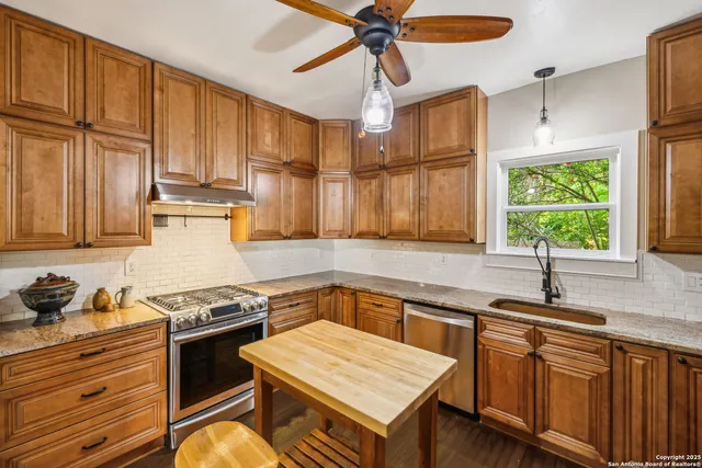 a kitchen with stainless steel appliances granite countertop a sink stove and cabinets