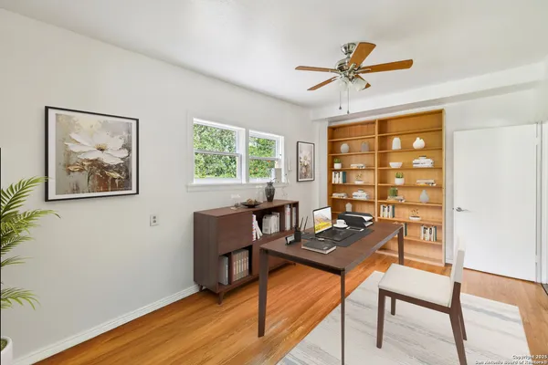 a view of a workspace with furniture and a window