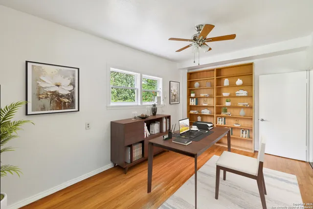 a view of a workspace with furniture and a window
