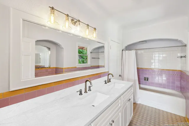 a bathroom with a sink a large mirror and a bathtub