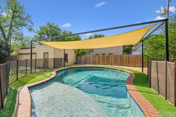 a view of a backyard with wooden fence