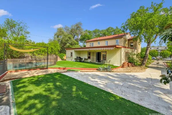 a view of a house with backyard and a tree