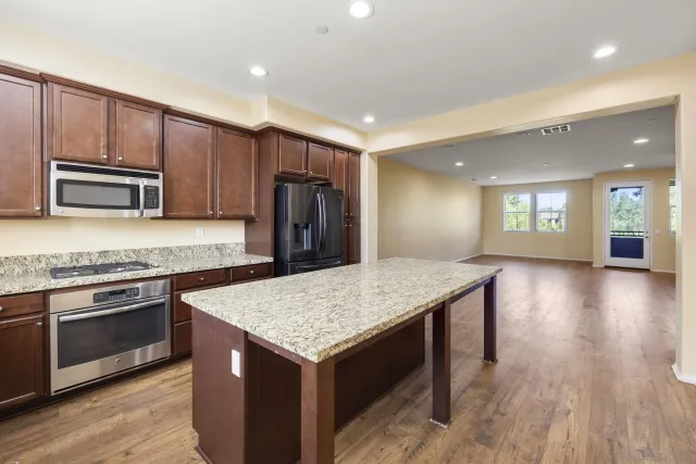 a kitchen with kitchen island a sink dishwasher stove and oven with wooden floor