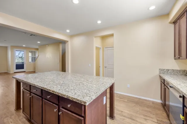 a kitchen with granite countertop cabinets and wooden floor