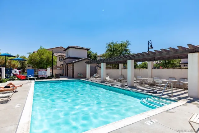 a patio with a table and chairs and potted plants