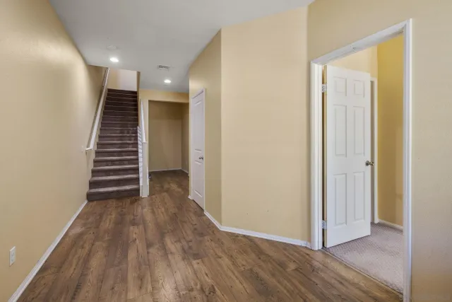 a view of a hallway with wooden floor and stairs