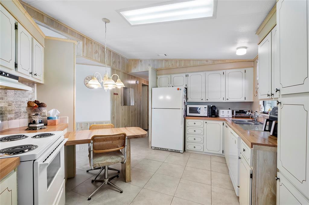 8600 Southwest 16th Place Davie, FL 33324 - Photo 2 of 20 a kitchen with cabinets a refrigerator and a stove top oven