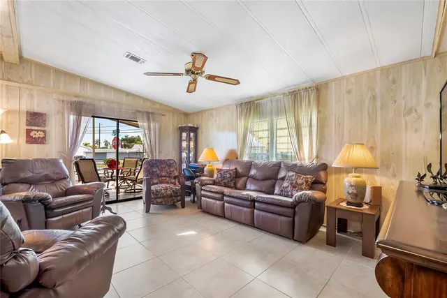 a living room with furniture a ceiling fan and a window