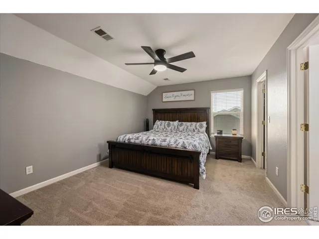 a living room with a bed and a ceiling fan