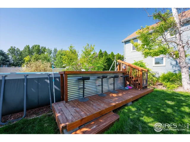 a view of a wooden deck and a backyard