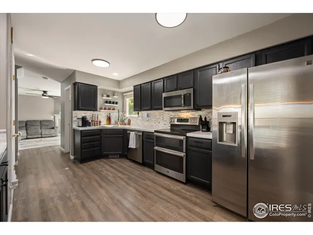 a kitchen with kitchen island a counter top space stainless steel appliances and cabinets