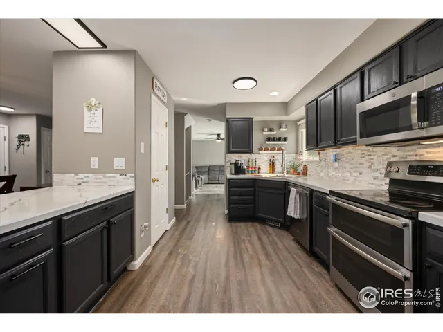 a kitchen with stainless steel appliances kitchen island granite countertop a sink dishwasher stove and microwave