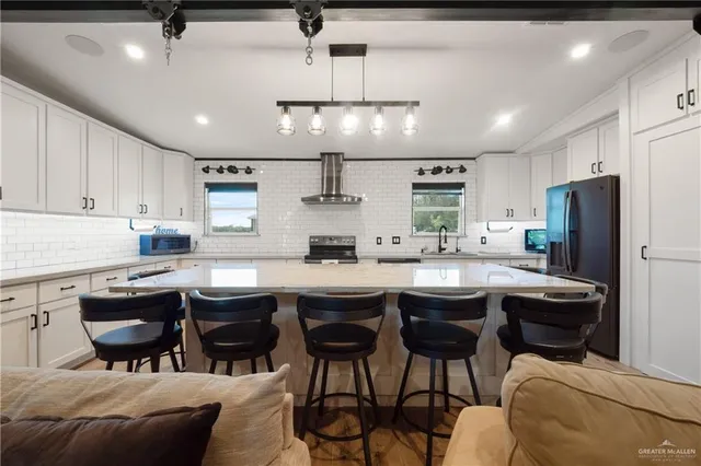 a kitchen with stainless steel appliances granite countertop a table chairs sink refrigerator and microwave