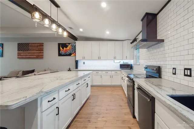 a kitchen with stainless steel appliances granite countertop a sink dishwasher stove and refrigerator