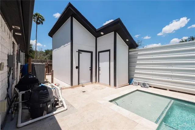 a view of a house with backyard barbeque and wooden fence