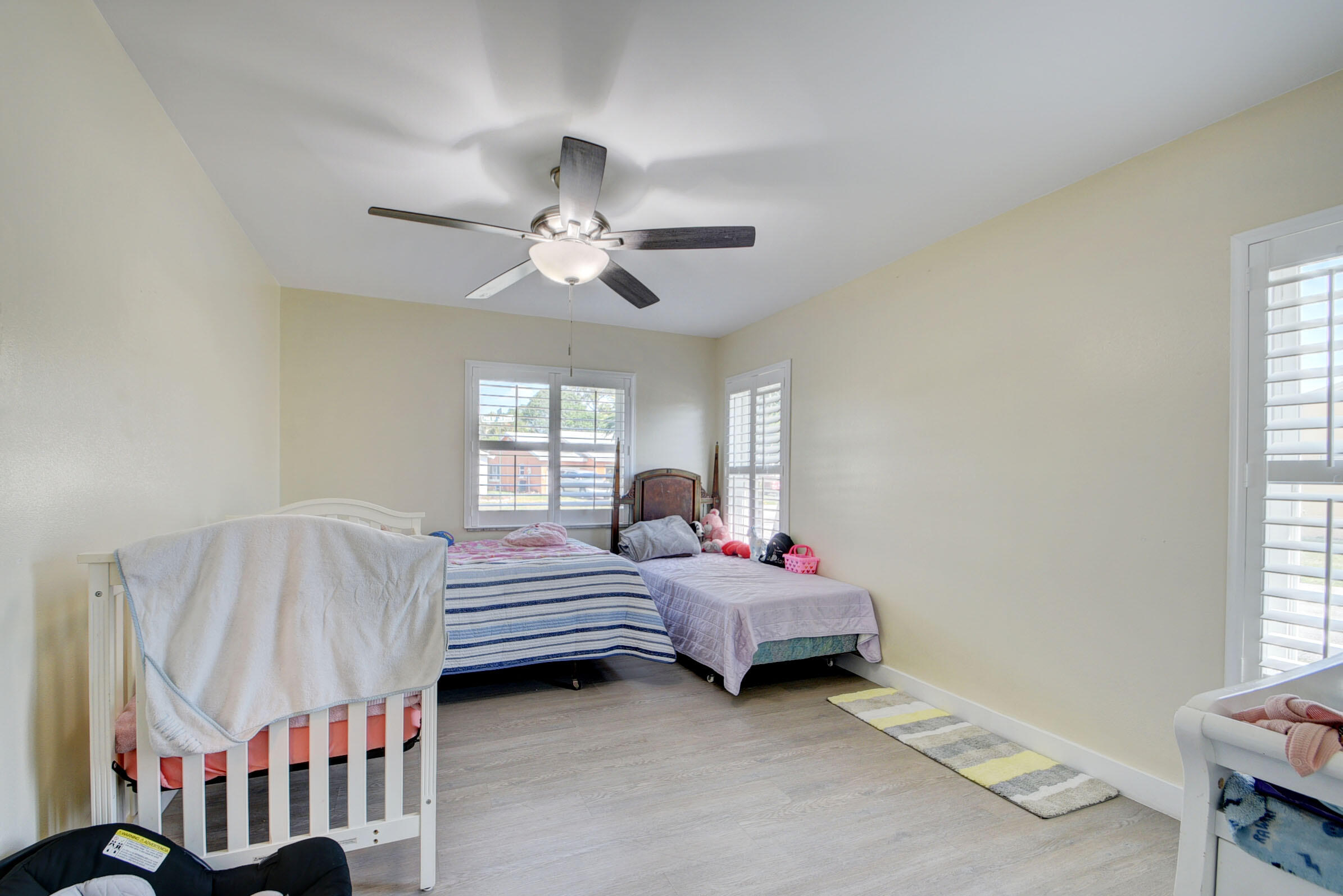 7258 Pine Manor Drive Lake Worth, FL 33467 - Photo 16 of 39 a spacious bedroom with a bed and a chandelier