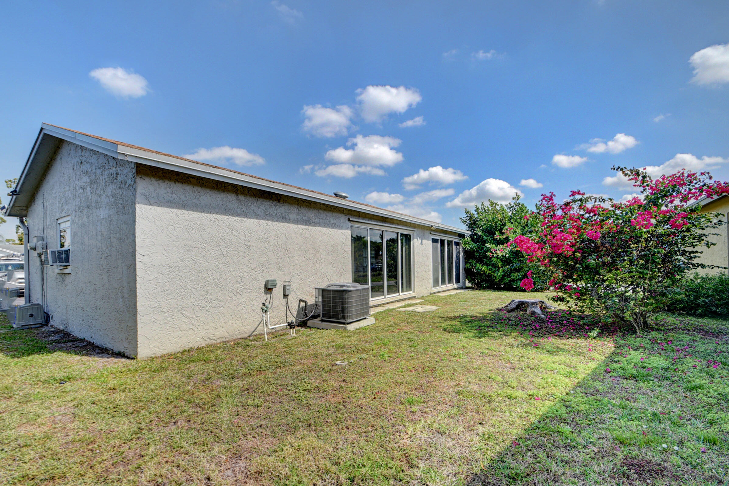 7258 Pine Manor Drive Lake Worth, FL 33467 - Photo 27 of 39 a view of a house with a yard and a garden