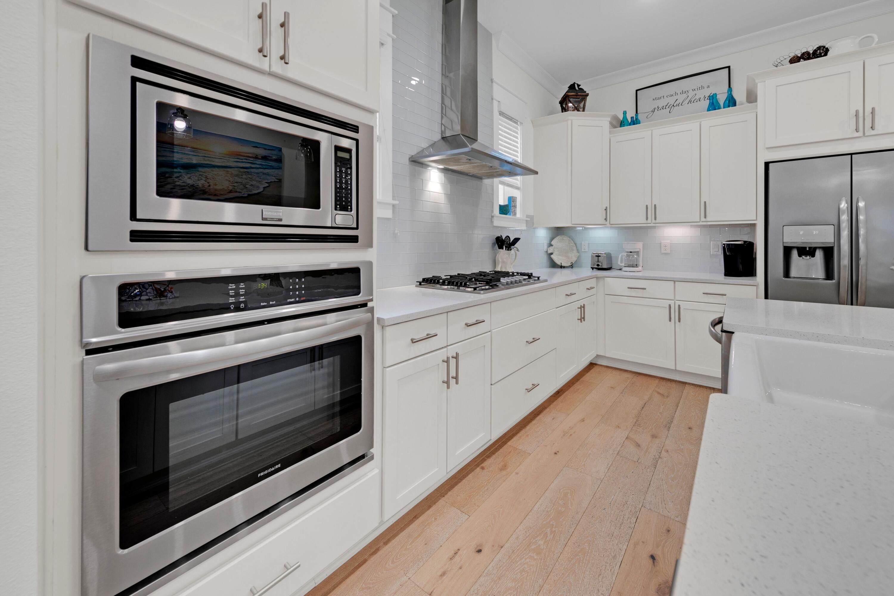209 Milestone Dr Inlet Beach, Unit B Inlet Beach, FL 32461 - Photo 20 of 39 a kitchen with granite countertop cabinets stainless steel appliances and wooden floor