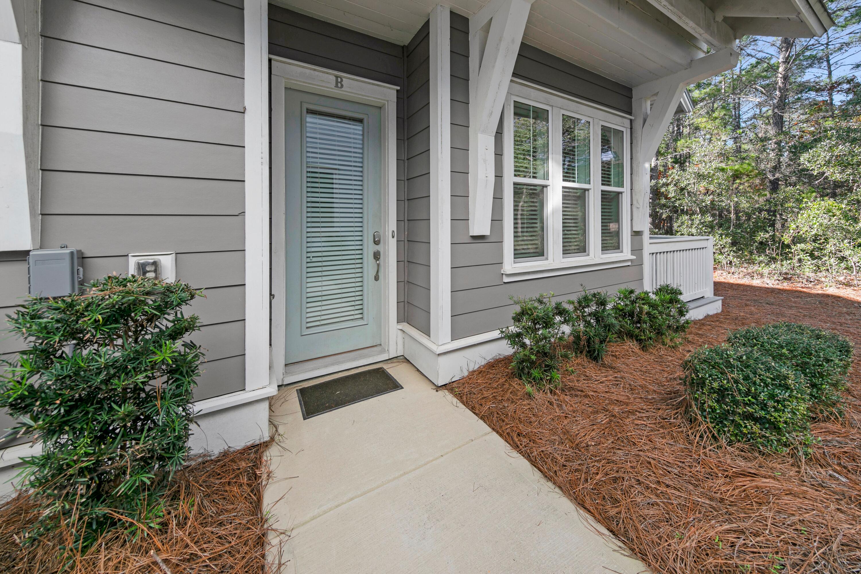 209 Milestone Dr Inlet Beach, Unit B Inlet Beach, FL 32461 - Photo 2 of 39 a house with potted plants in front of door