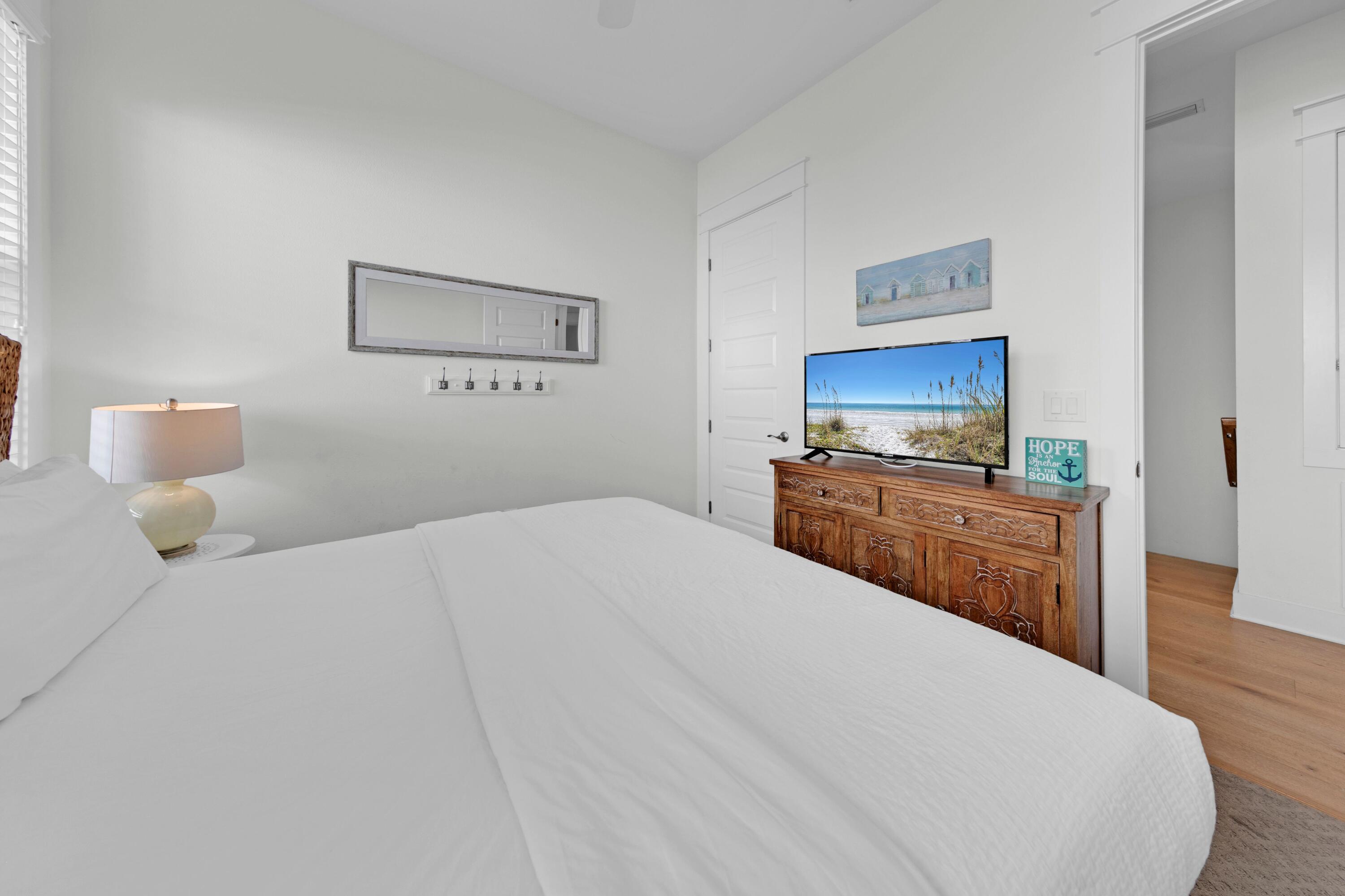 209 Milestone Dr Inlet Beach, Unit B Inlet Beach, FL 32461 - Photo 34 of 39 a bedroom with a bed and a flat screen tv