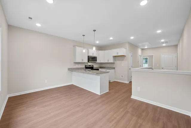 a kitchen with a refrigerator and white cabinets