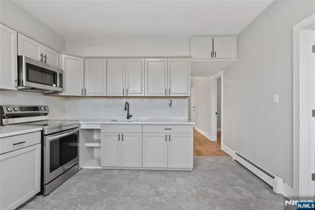 a kitchen with white cabinets stainless steel appliances and a sink
