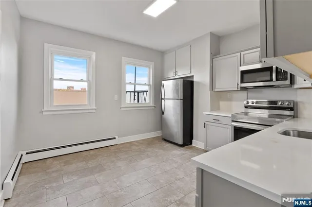 a kitchen with stainless steel appliances a refrigerator sink and microwave