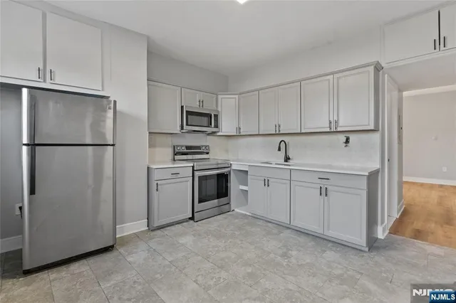 a kitchen with white cabinets and white appliances