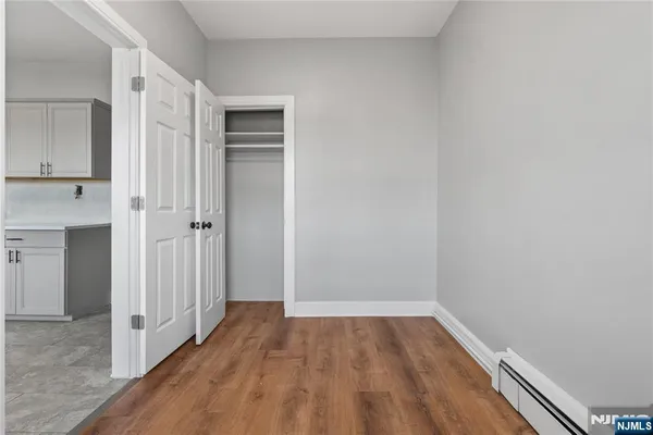 a view of a room with wooden floor and a hallway