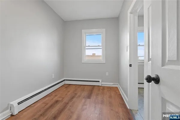 a view of a room with wooden floor and white walls