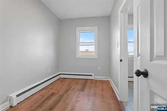a view of a room with wooden floor and white walls