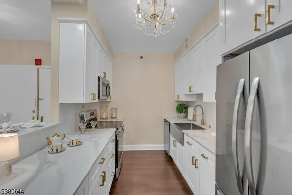 a kitchen with kitchen island granite countertop a sink appliances cabinets and counter space