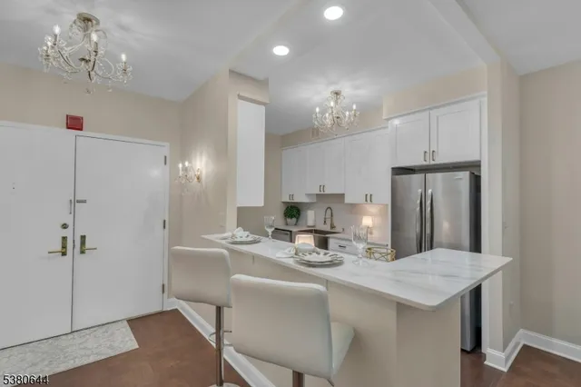 a view of a dining room with furniture a chandelier and wooden floor