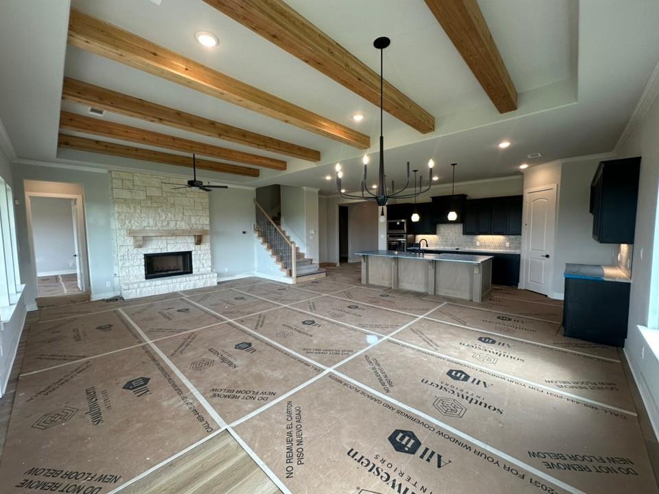 295 Brown Road Leonard, TX 75452 - Photo 12 of 28 Spacious living area featuring a stone-clad fireplace, wood-beamed ceiling, and recessed lighting