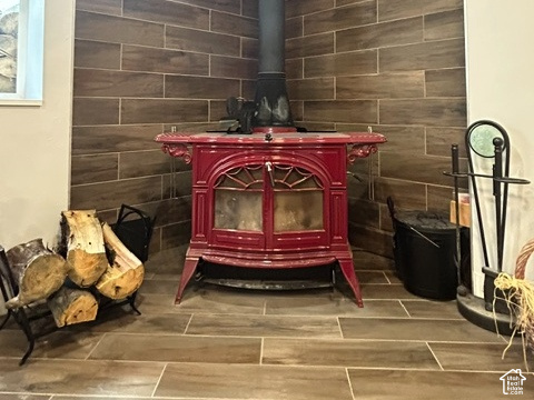 1750 West 4100 North Helper, UT 84526 - Photo 33 of 50 Corner wood-burning stove with a red finish, set against a tile-clad wall, featuring coordinating wood-look tile flooring