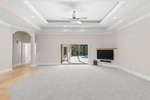 a view of an empty room with a window and a kitchen