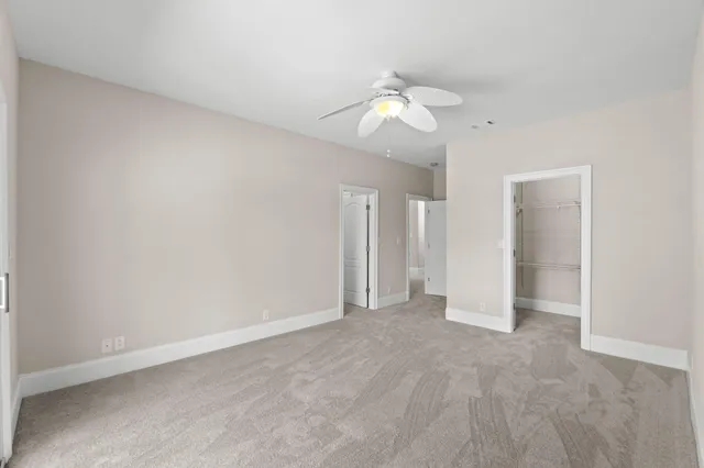 an empty room with a chandelier fan