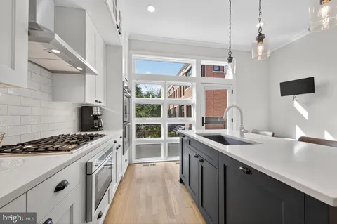 a kitchen with stainless steel appliances a sink stove and cabinets