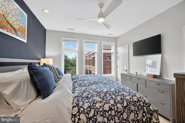 a bed room with a bed television and a large window