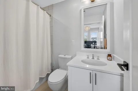 a bathroom with a sink a toilet and shower curtain