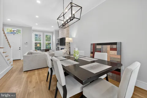 a view of a dining room with furniture a chandelier and wooden floor