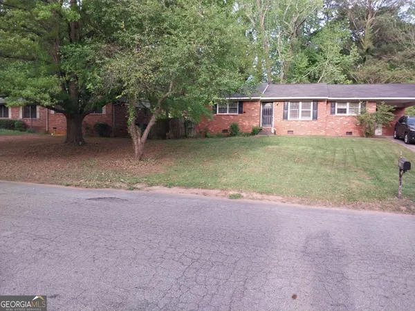 a view of a house with a yard and a tree