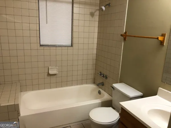 a bathroom with a white bath tub a toilet and a sink