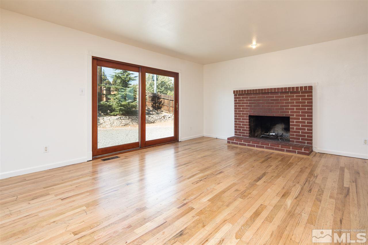 3301 Bryan Street Reno, NV 89503 - Photo 6 of 25 a view of an empty room with wooden floor fireplace and a window