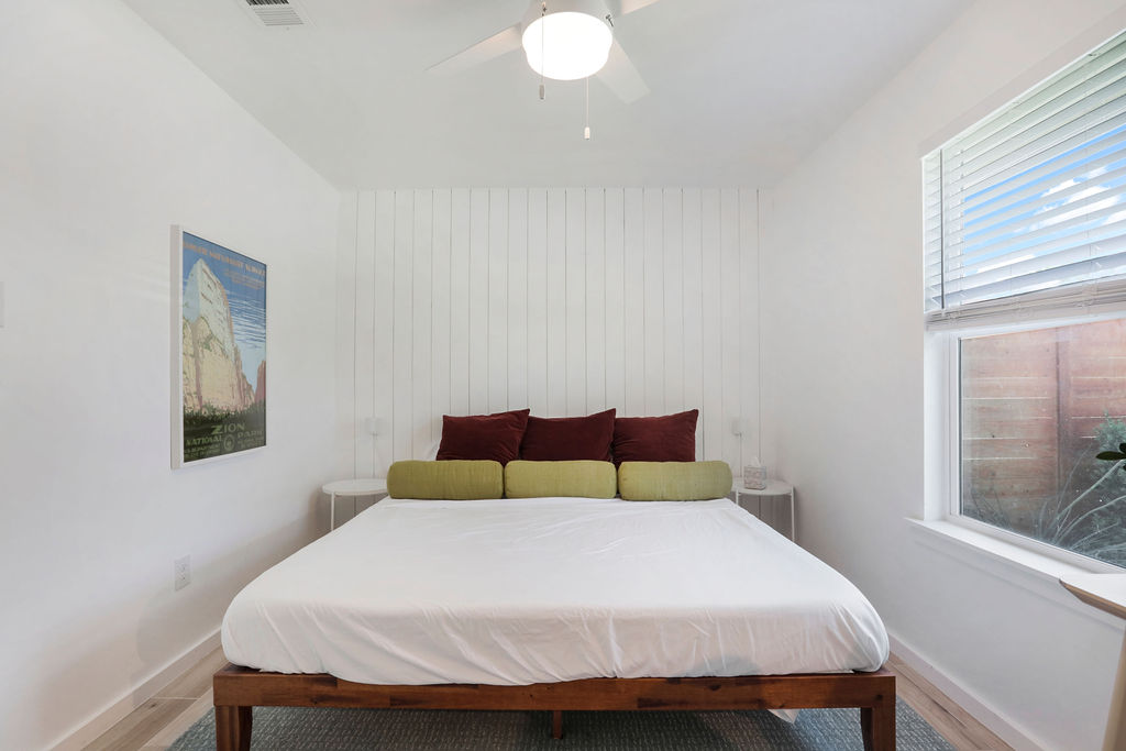 906 East Leslie Circle, Unit A Austin, TX 78721 - Photo 6 of 16 a bedroom with a bed and glass window